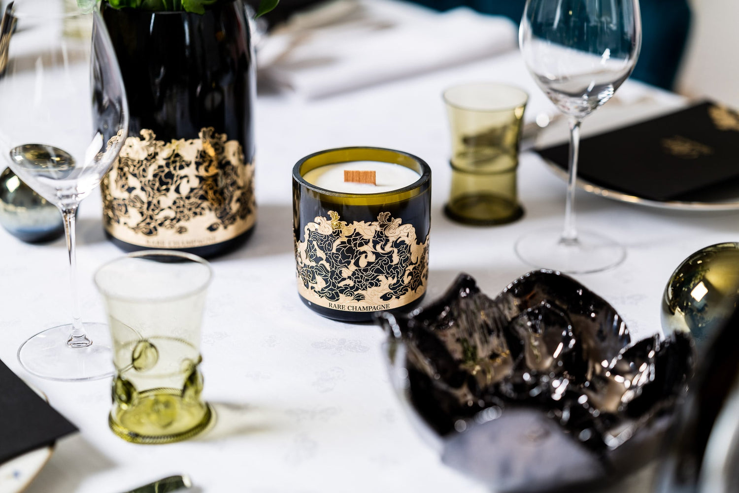 Bougie marsault réalisée dans une bouteille Rare champagne, posée sur une table dans un restaurant de luxe 