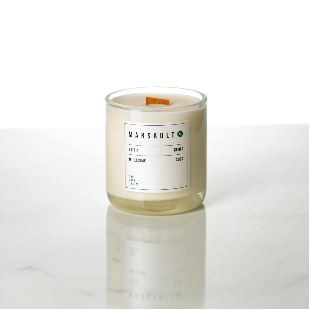 Bougie blanche éco-responsable champenoise de la gamme Marsault format bouteille avec mèche en bois, dans un studio photo blanc 
