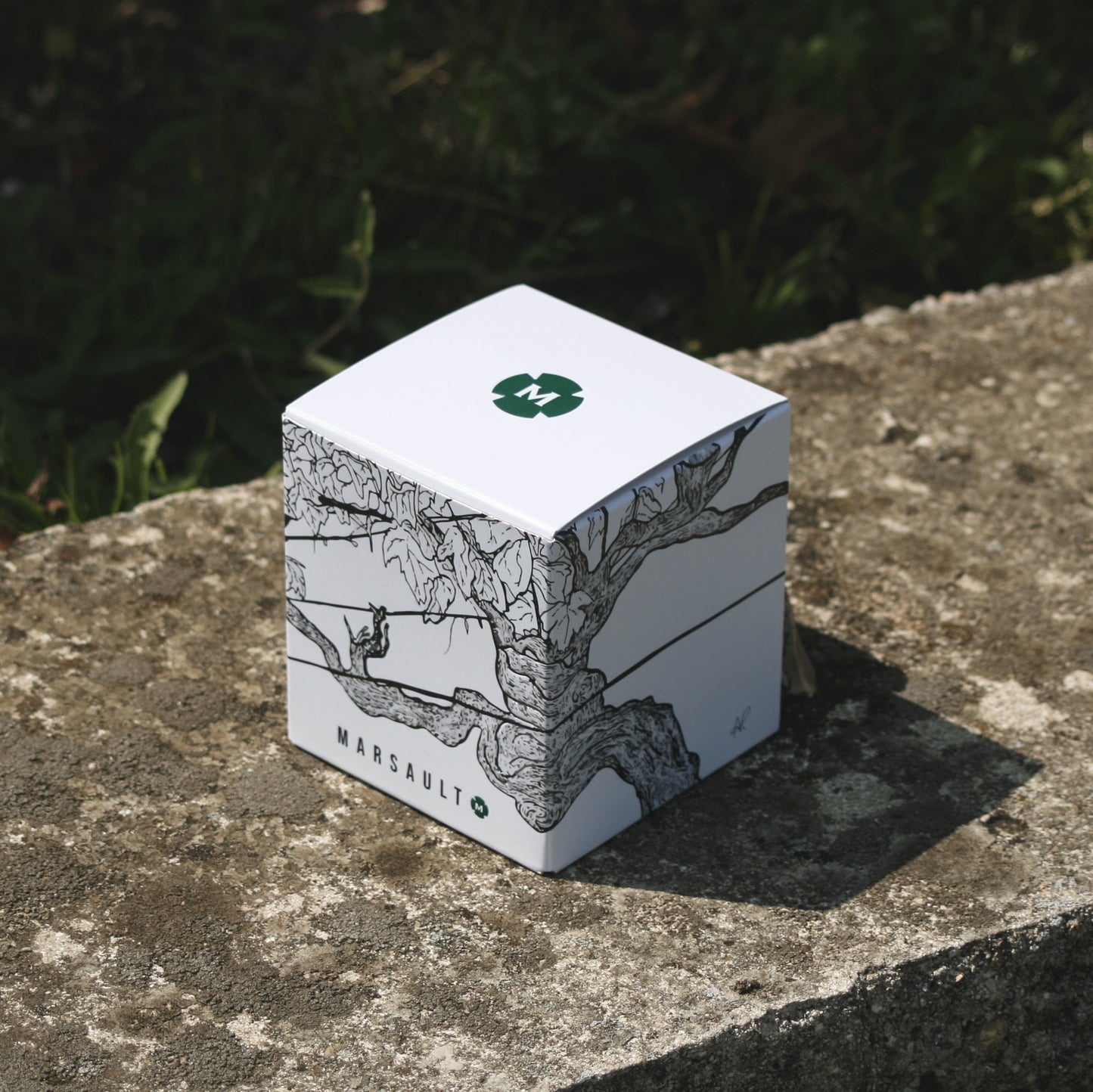 étui en carton personnalisé format magnum bougie Marsault Reims sur mur en pierre au soleil